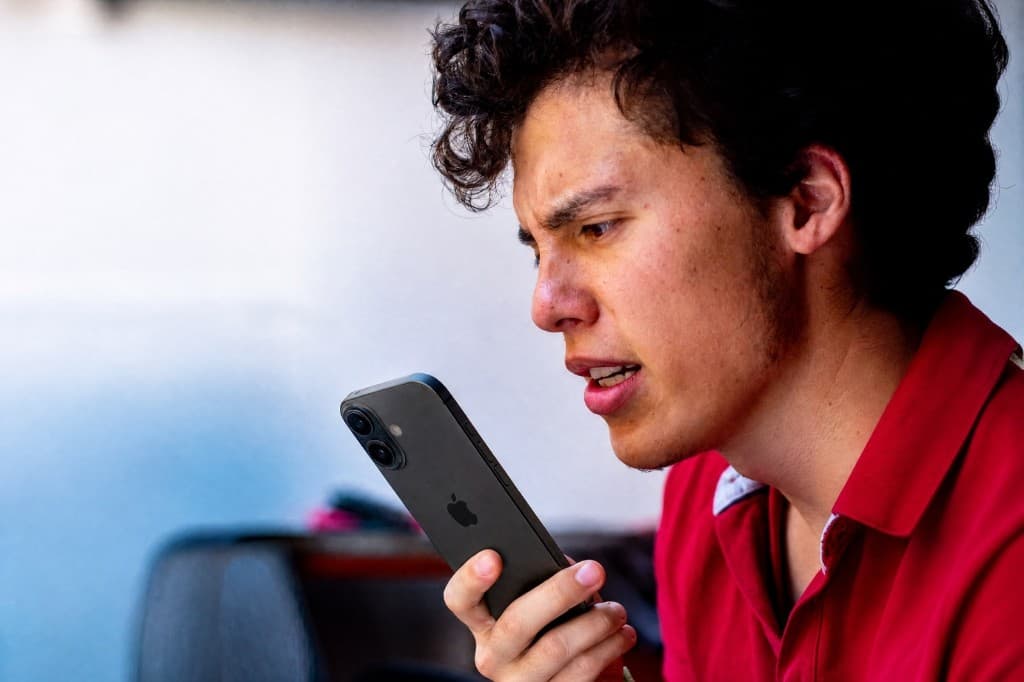 Persona hablando por el micrófono de su teléfono, concentrada en producir la frase.